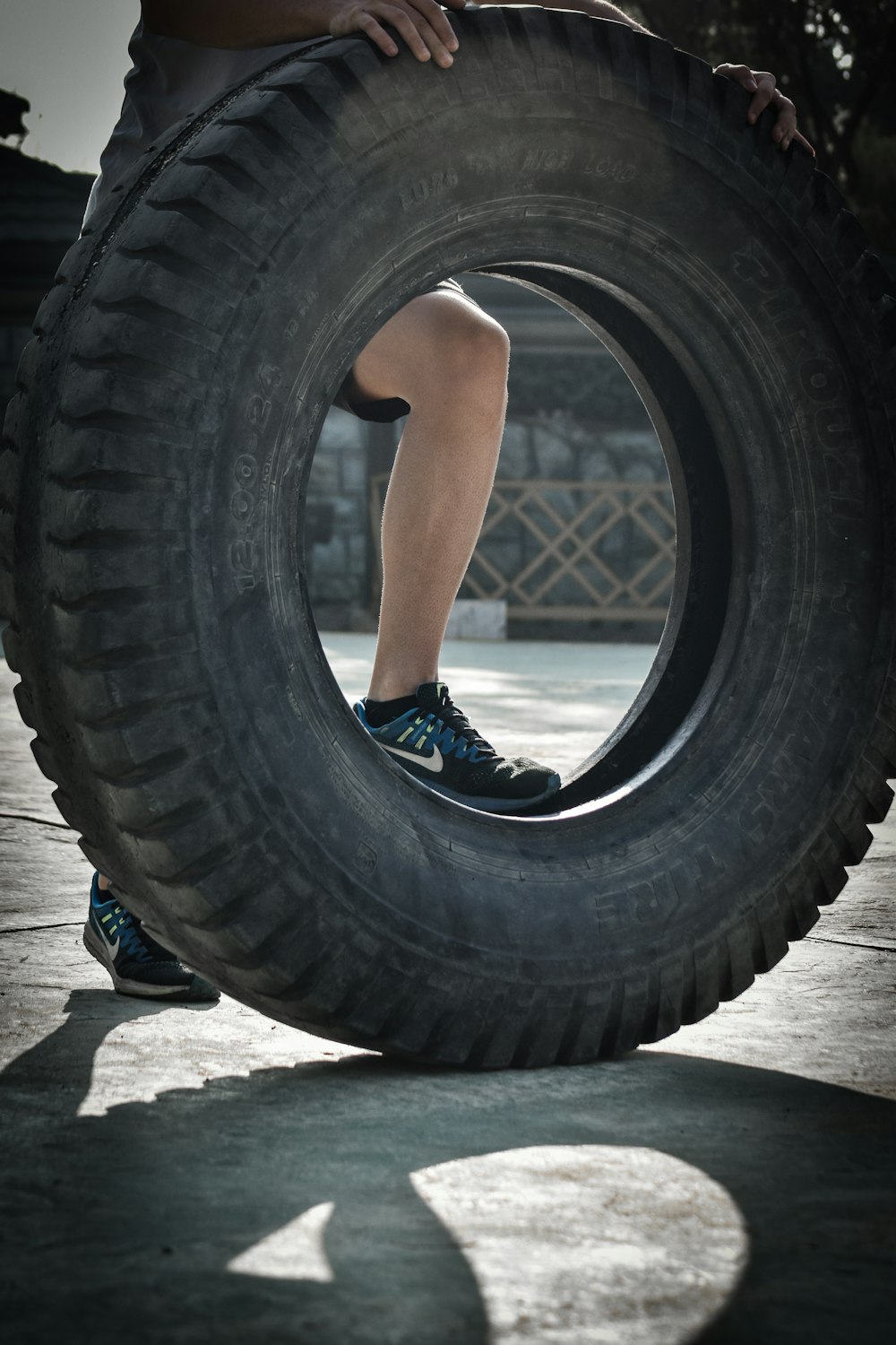 person touching car tire on gray floor