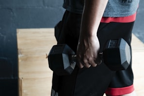 unknown person holding black dumbbell