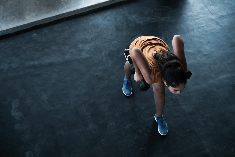 woman in orange top exercising indoors