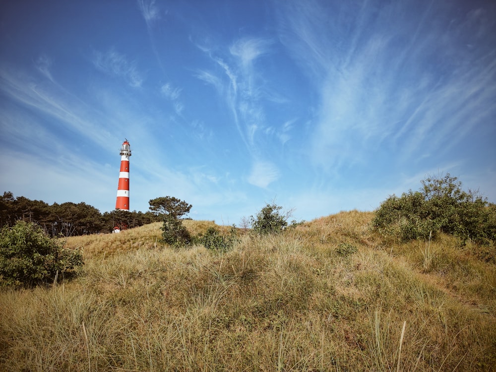 lighthouse on top of a mountain under a calm blue sky
