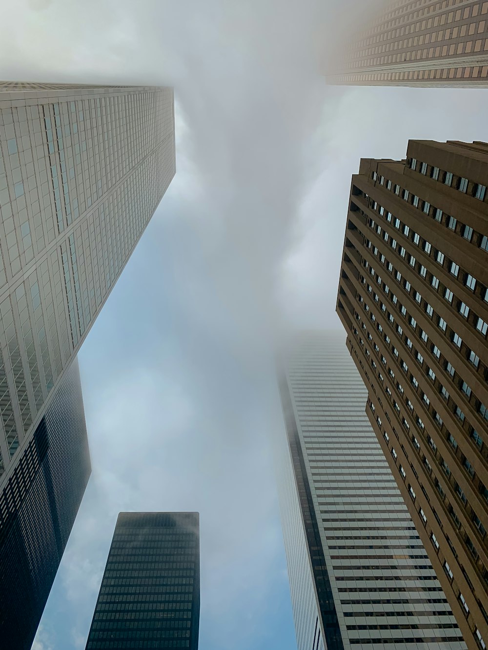 low-angle photography of high rise buildings under a cloudy sky
