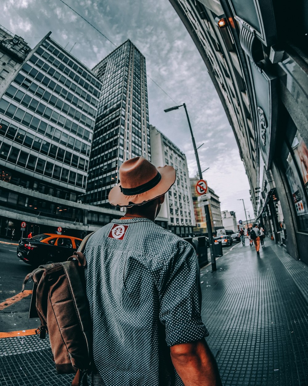 man walking on sidewalk of the city