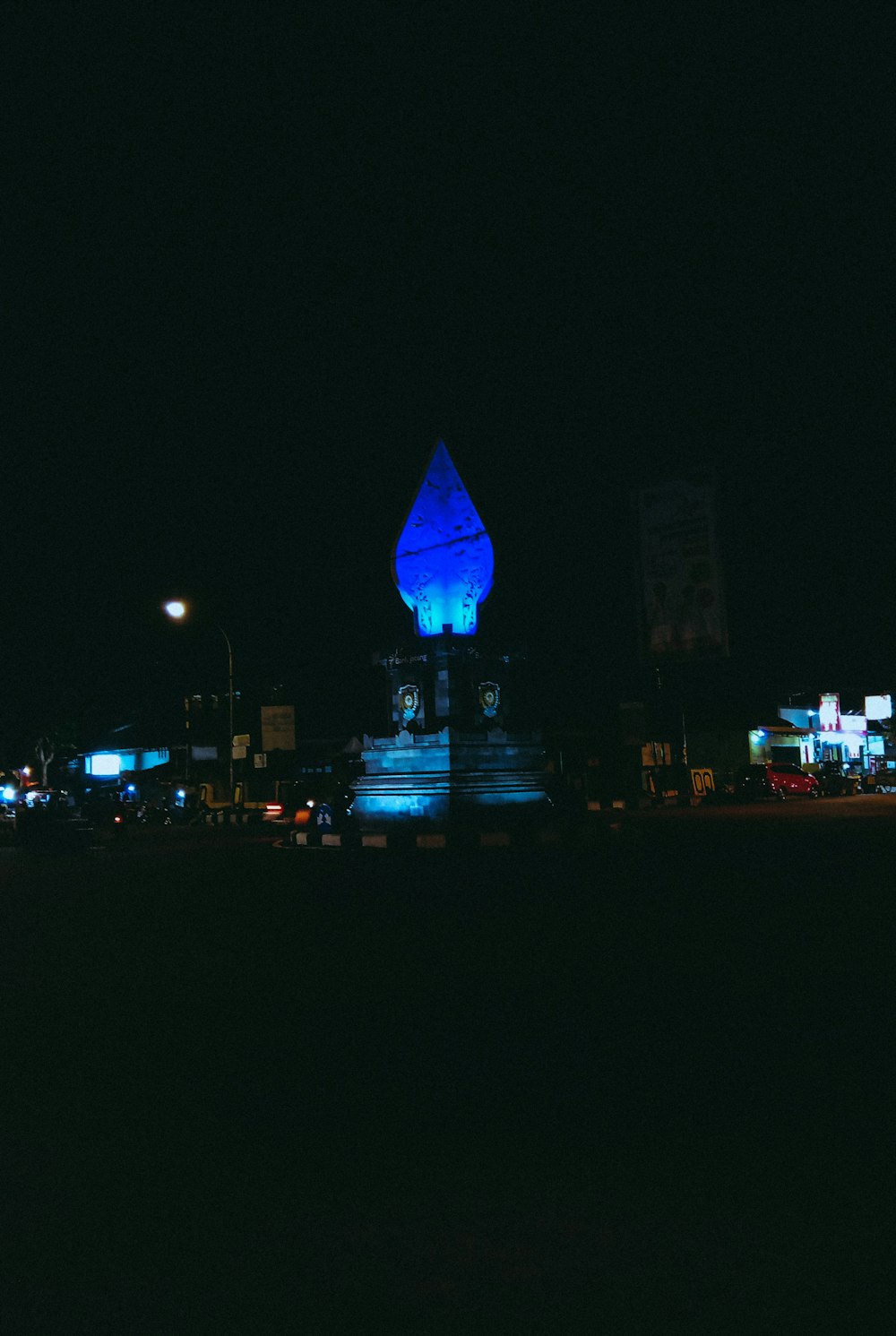 a night time view of a large building with a blue light on it