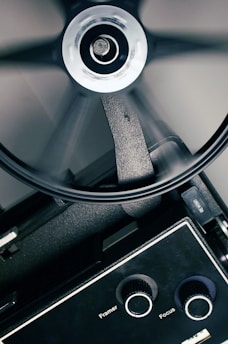 Close-up of a vintage Super 8 film reel being carefully handled by a technician.