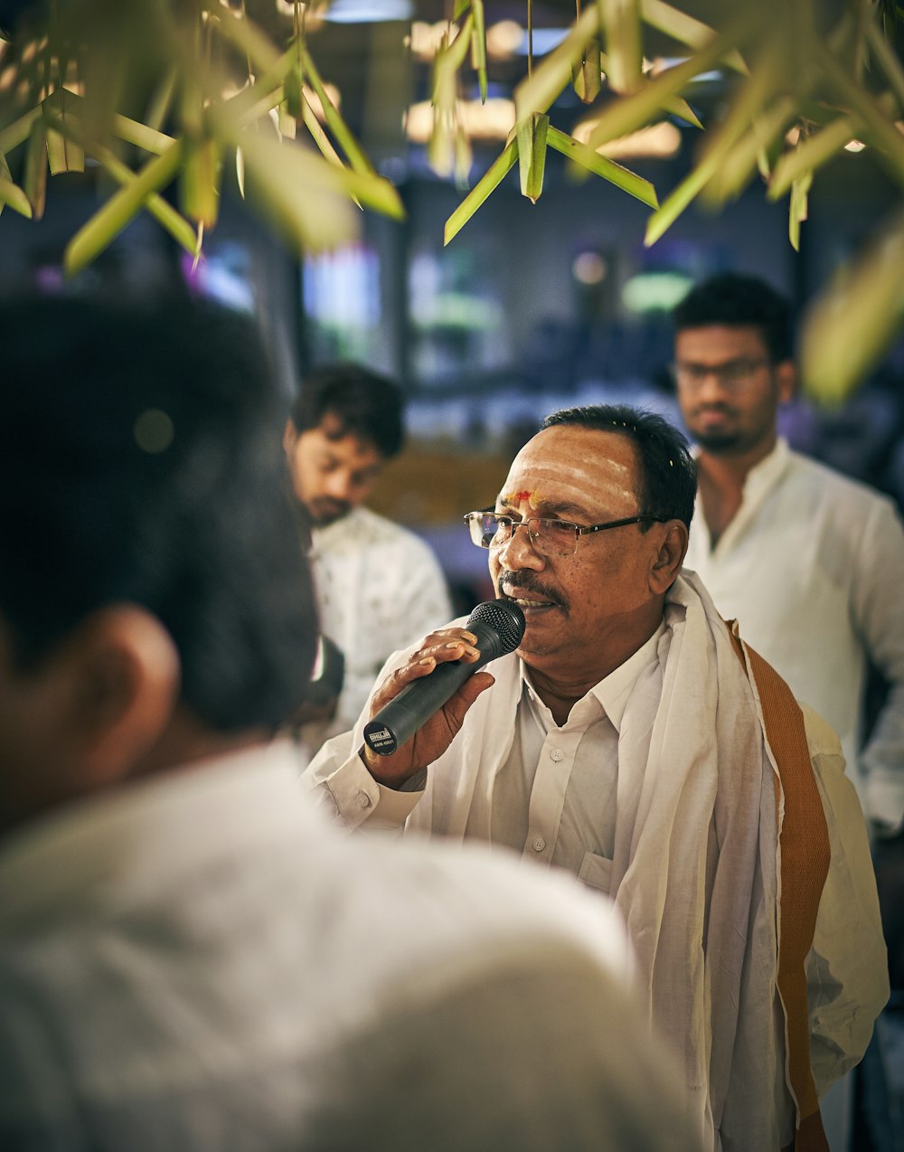 man wearing white dress shirt holding microphone