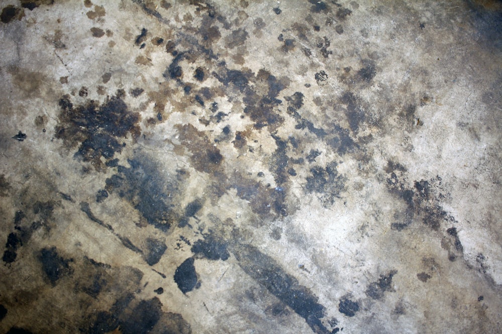 a close up of a dirty surface with black spots