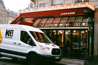 white van parked near restaurant building during daytime