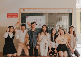 seven persons kneeling near wall during daytime