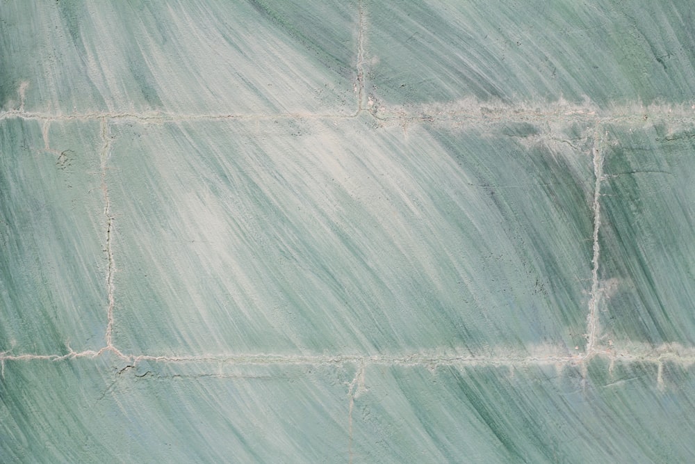 uma parede de azulejo verde com linhas brancas