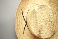 Artistic close-up of a straw hat similar to that on the 'Chapeau de Paille' book cover.