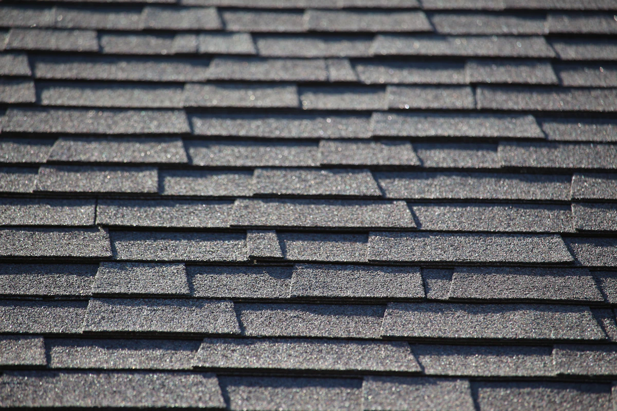 Crisp new charcoal-gray asphalt shingle roof after replacement