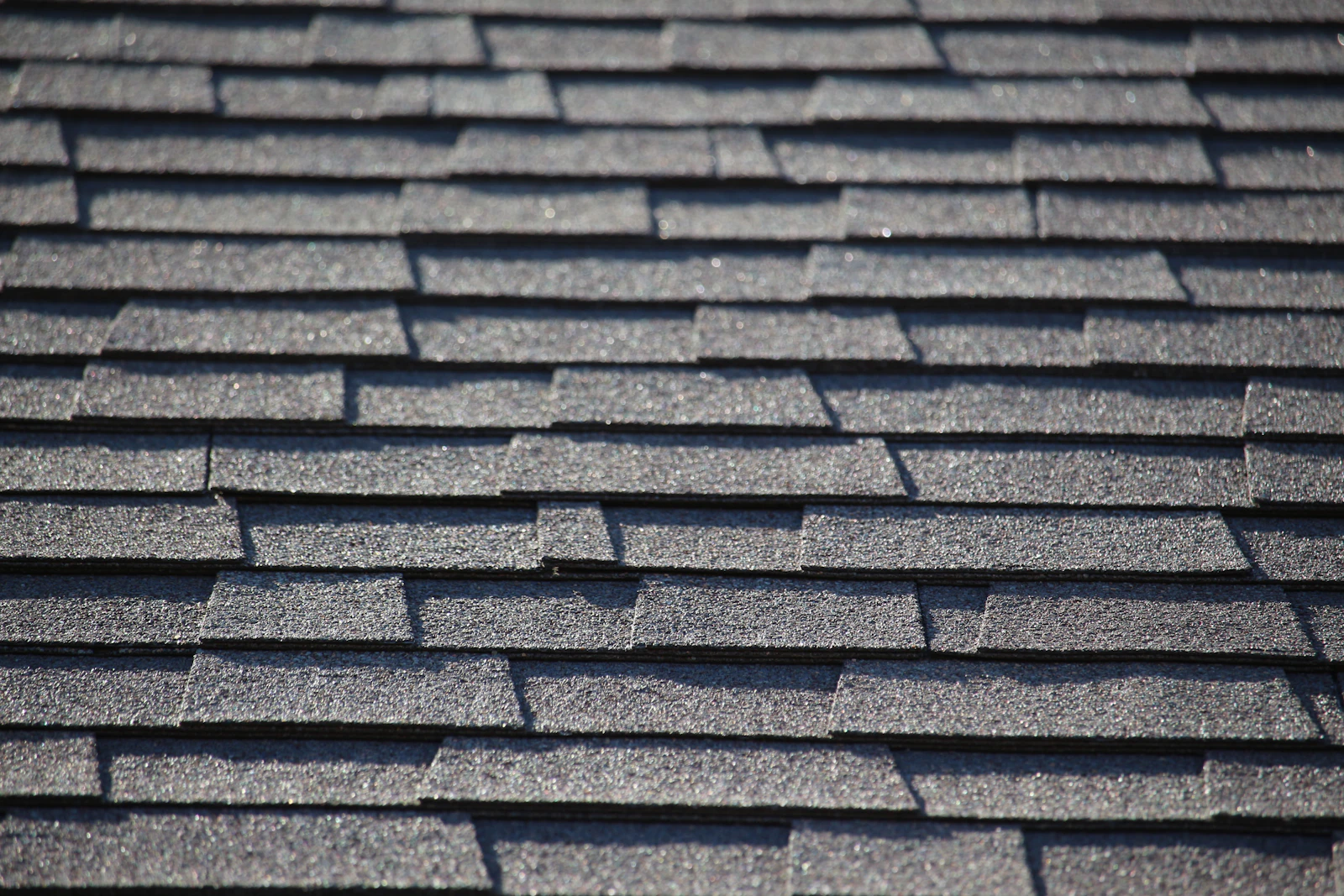 Crisp new charcoal-gray asphalt shingle roof after replacement