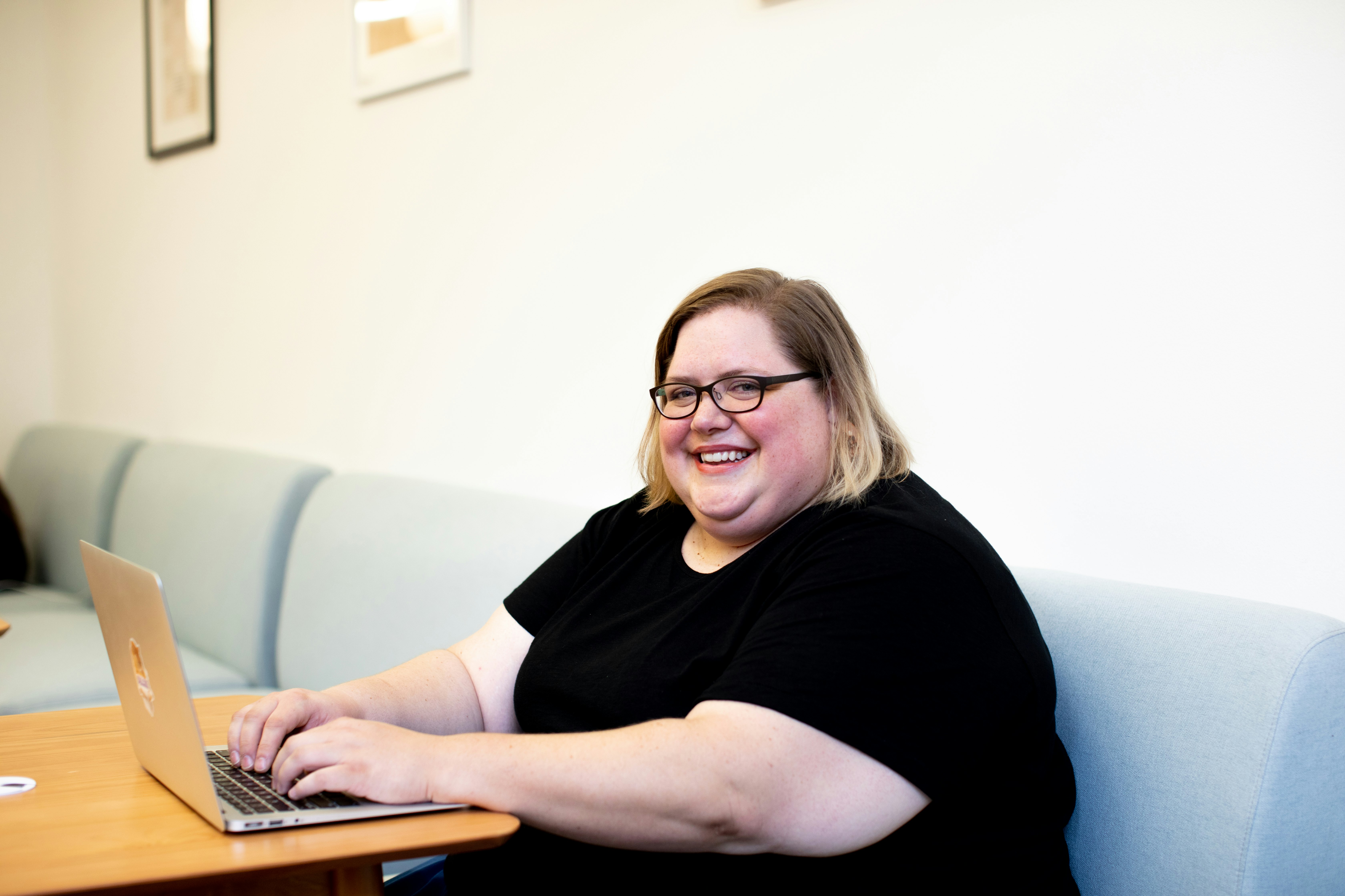 Plus size woman on computer in bright, modern, open office
