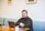 man sitting on sofa using laptop