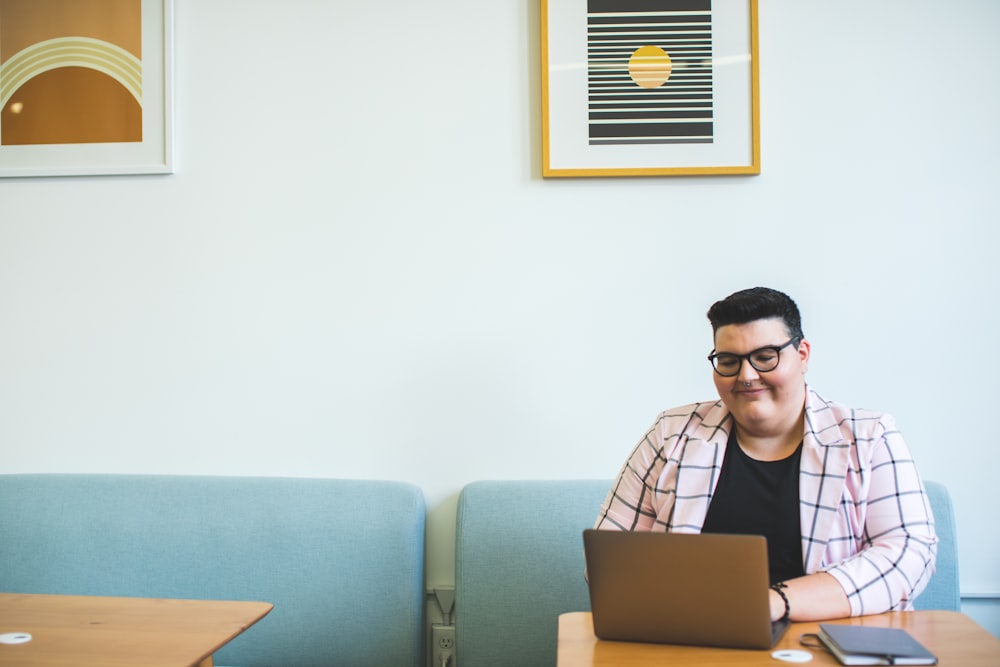 hombre sonriente sentado en la silla usando la computadora portátil