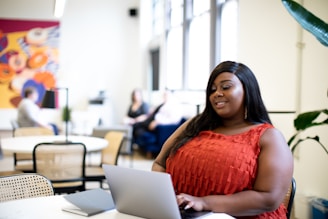 A woman working at home, smiling as she connects with others online.