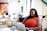 A smiling businesswoman working on a laptop in a bright modern office.
