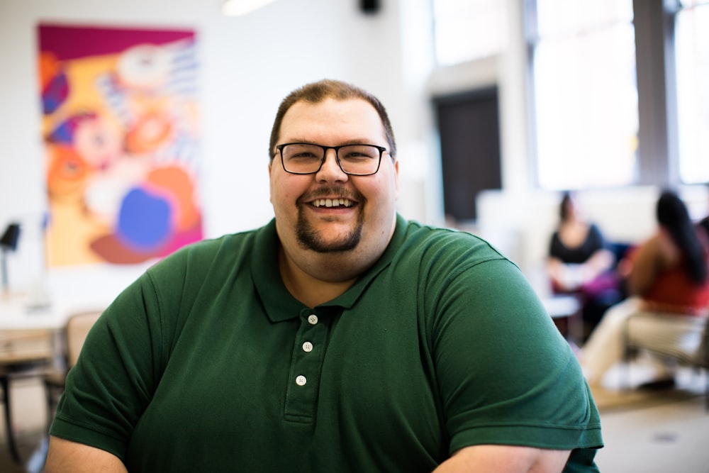 man sitting down wearing green polo shirt