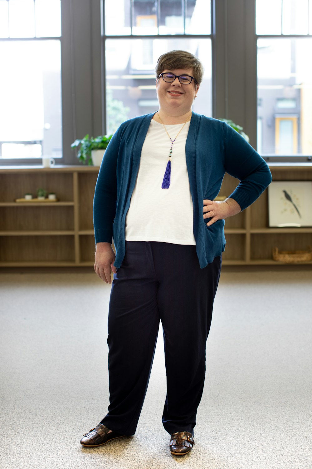 man in blue cardigan and black pants