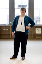 A confident woman reviewing her financial plan in a bright, airy workspace filled with plants and soft natural light.