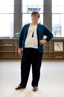 A candid shot of a student confidently presenting in a cozy study space with nude beige walls.