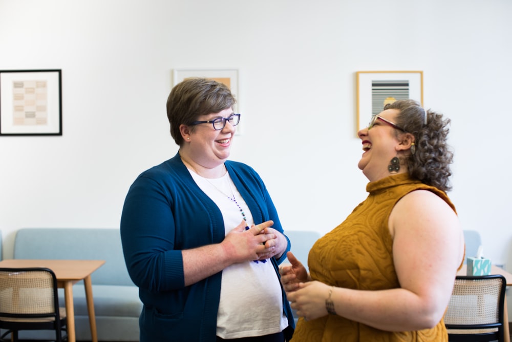 two smiling woman standing inside room