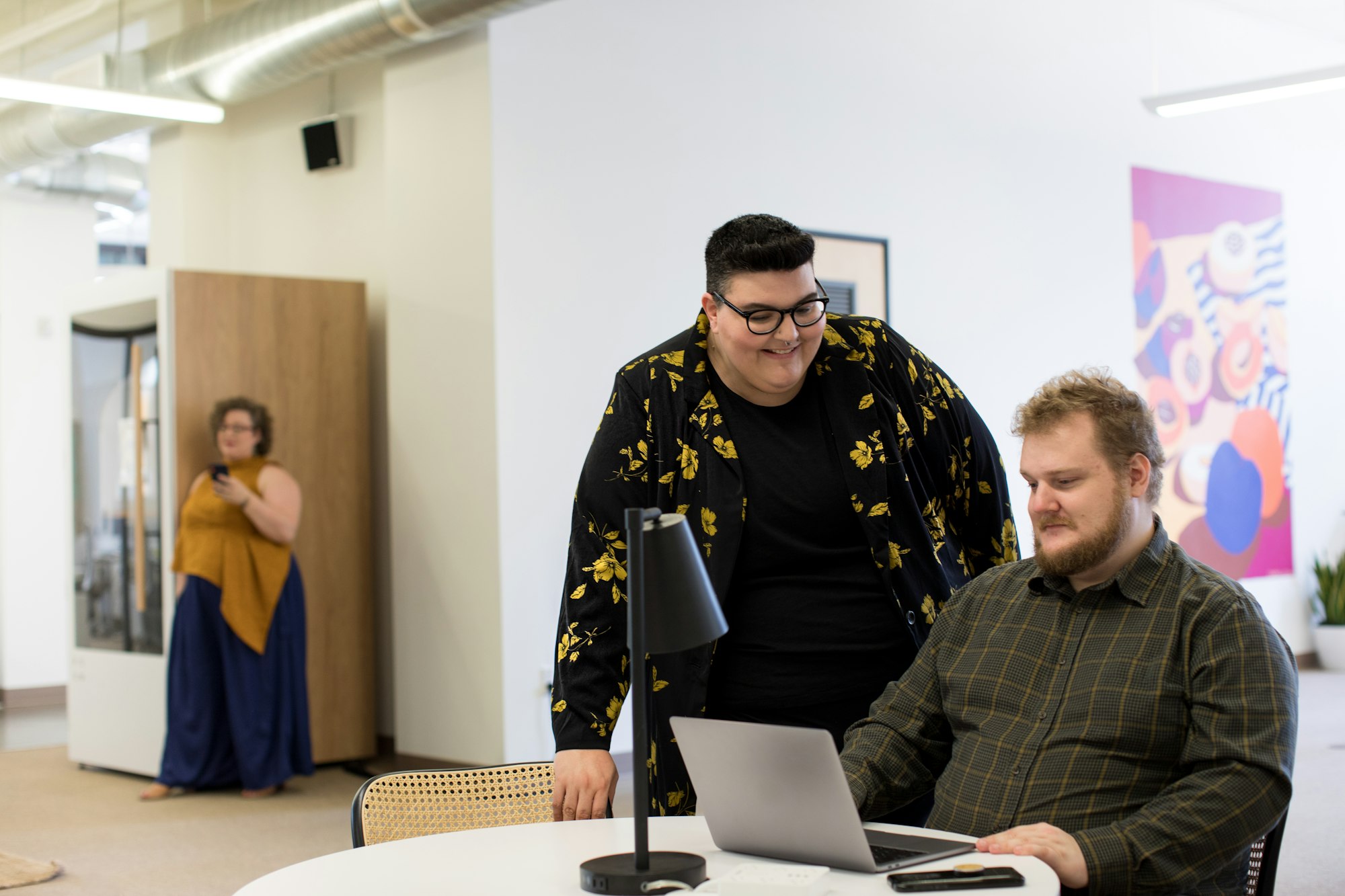 Group of plus size employees in a modern, bright open office working on computer