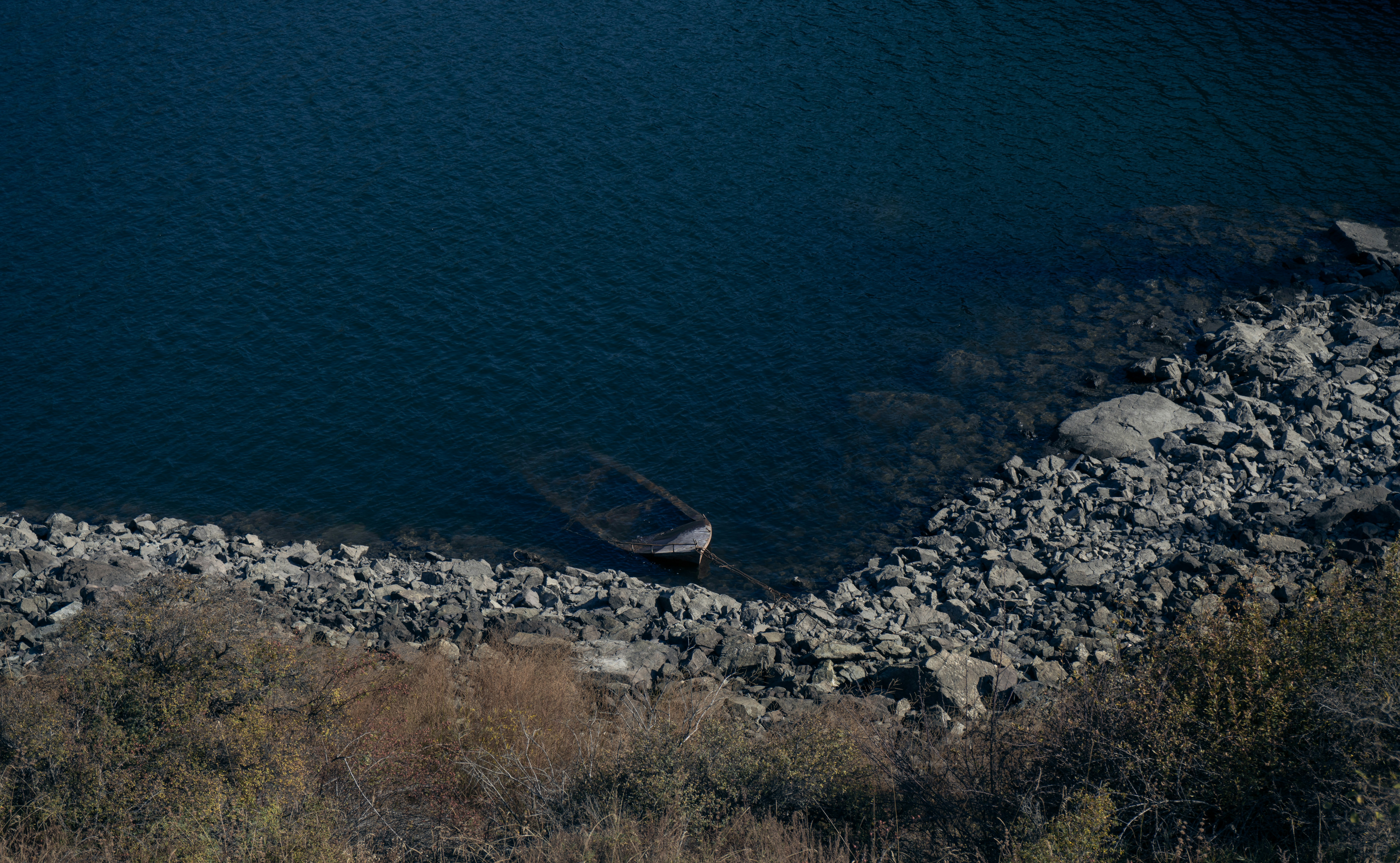 brown boat beside body of water