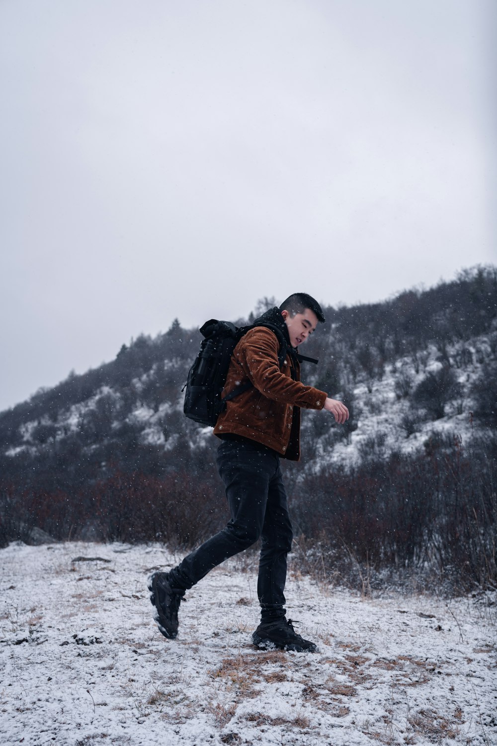 man standing on snow near mountain during daytime
