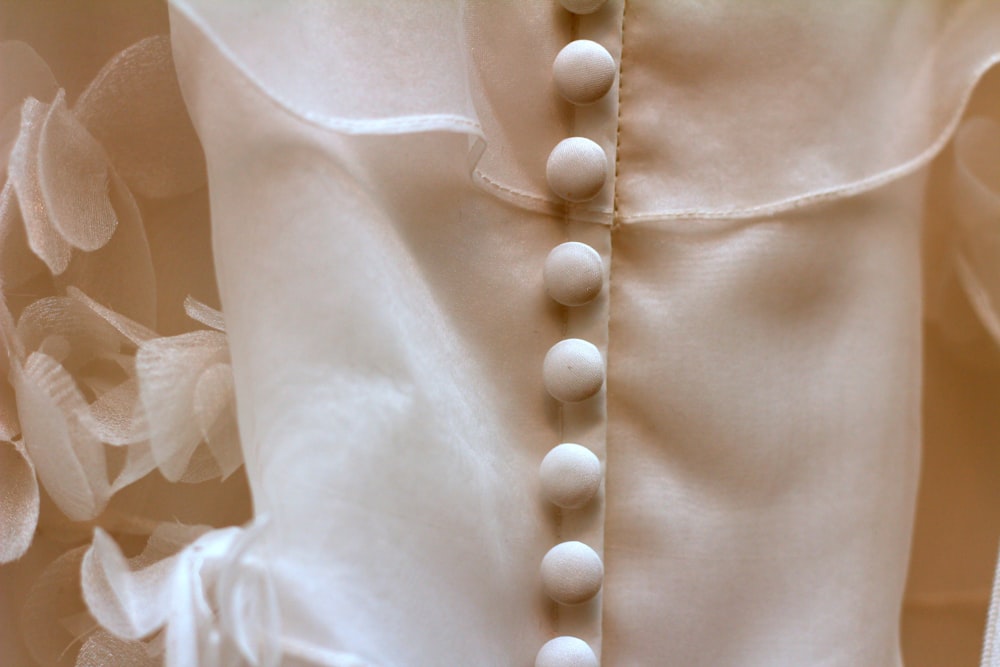a close up of a dress with buttons on it