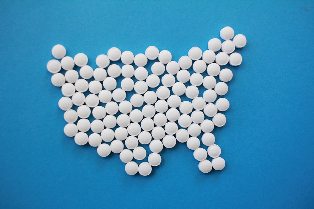 Fotografia piatta di compresse di prescrizione bianche in superficie blu