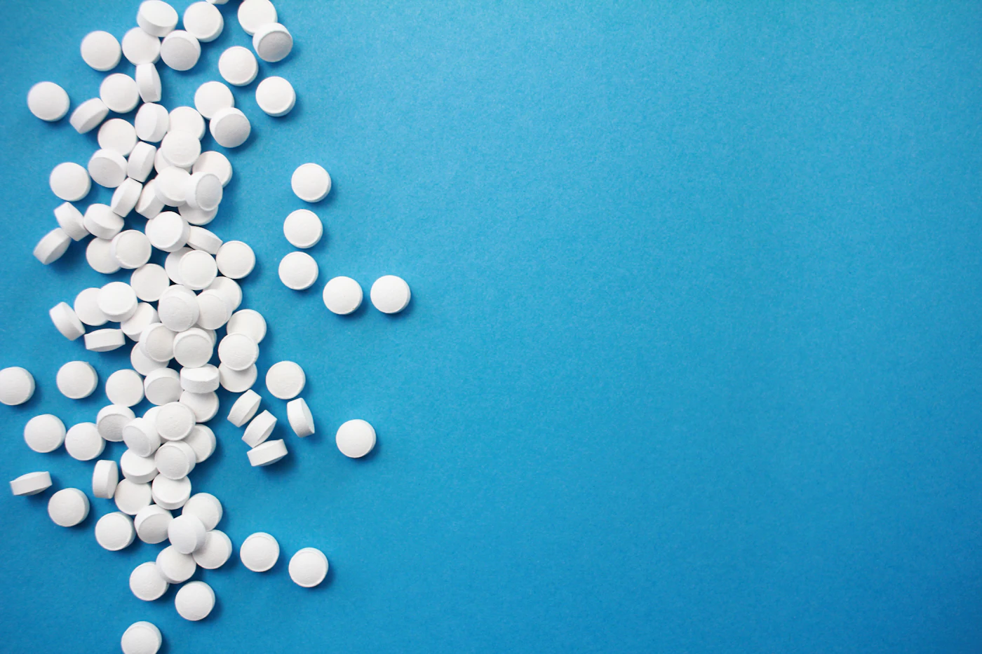 Round white tablets on a blue background