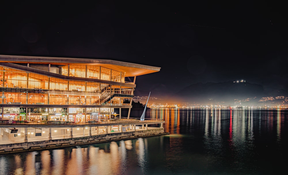 a building on the edge of a body of water at night