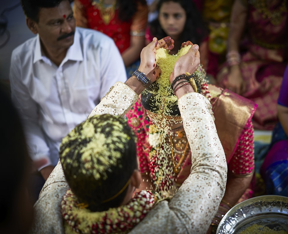 man standing while pouring substance on head of woman in wedding ceremony