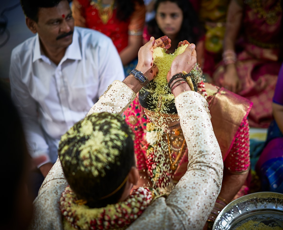 man standing while pouring substance on head of woman in wedding ceremony