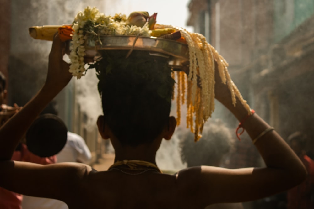 a man carrying a bowl of food on his head