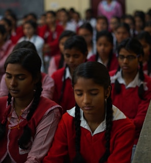 girls sitting in a classroom with eyes closed