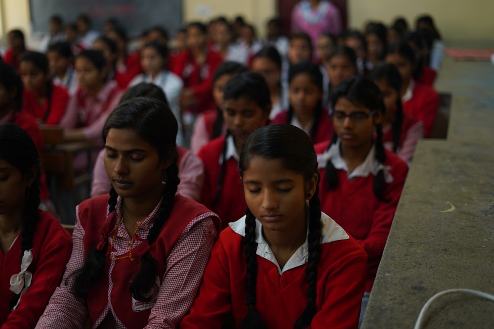 girls sitting in a classroom with eyes closed