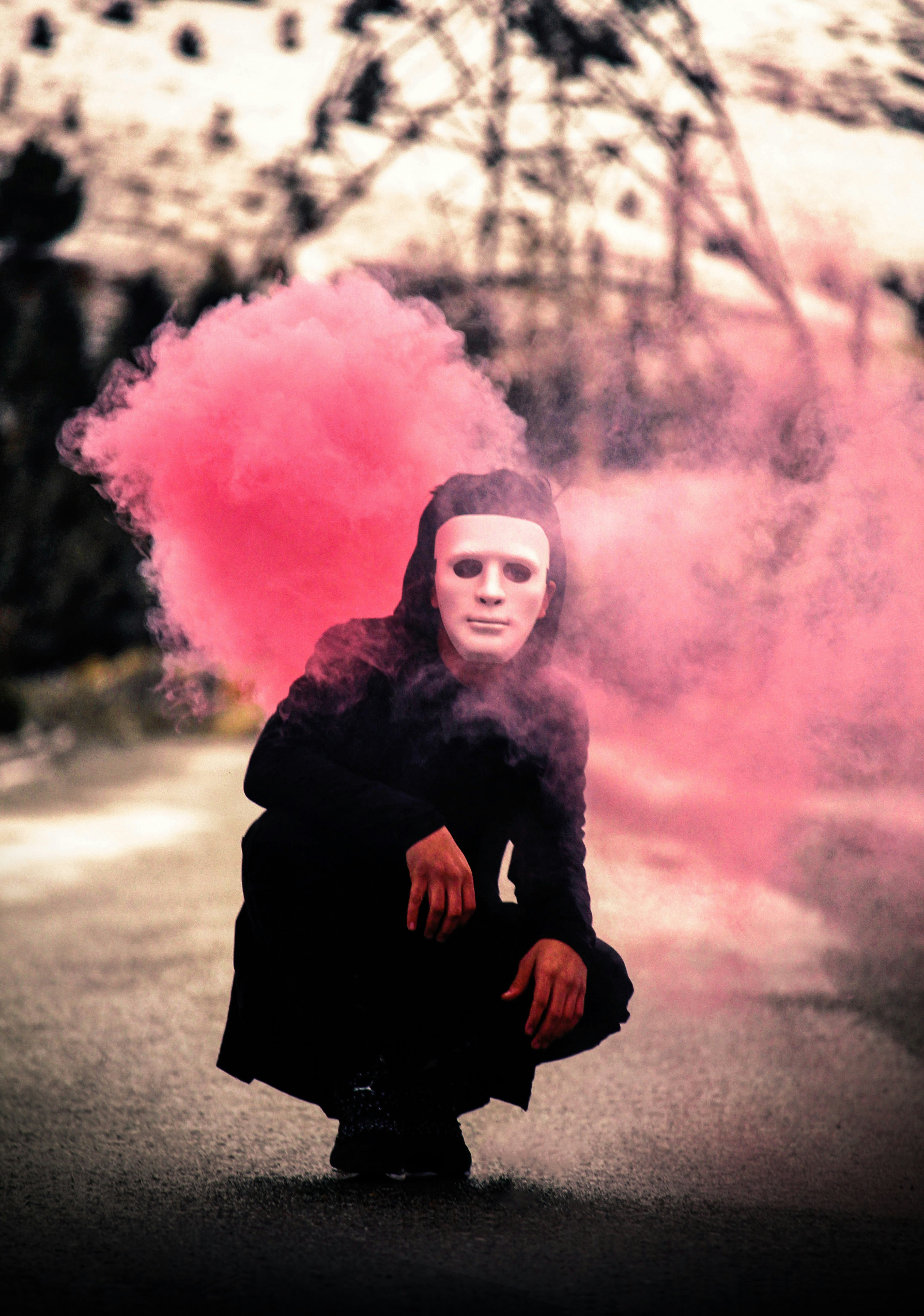 person with mask near pink smoke