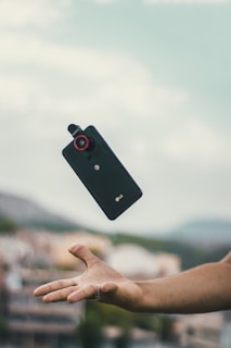 A person reaching out with a smartphone in hand.