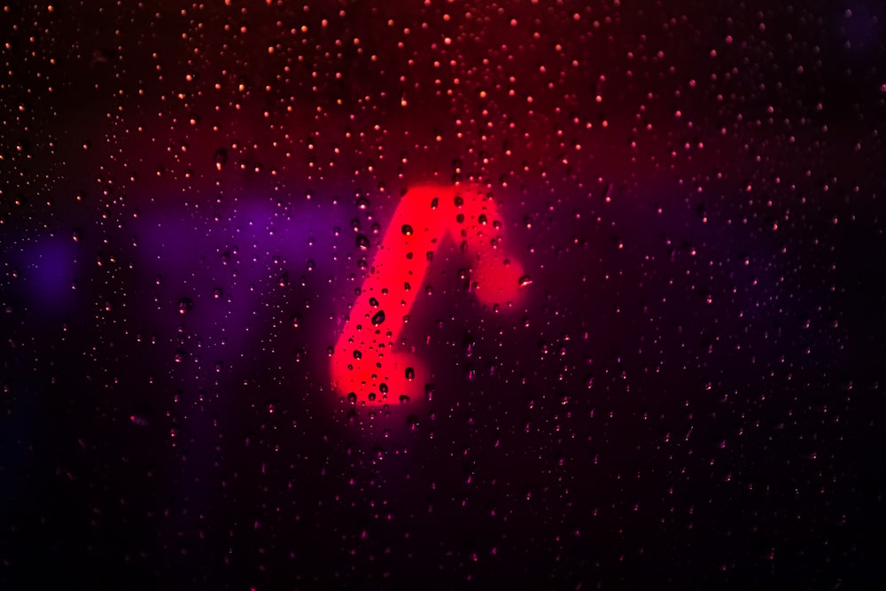 a red letter on a window with rain drops