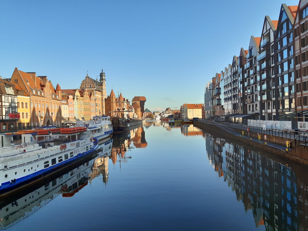 boats on body of water near buildings during daytime