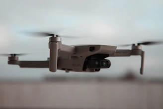 Close-up of a sleek custom FPV drone with neon blue accents flying indoors.