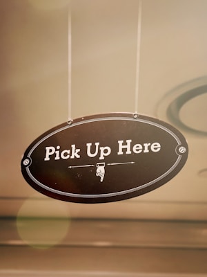 A school building with a sign indicating product pickup hours.