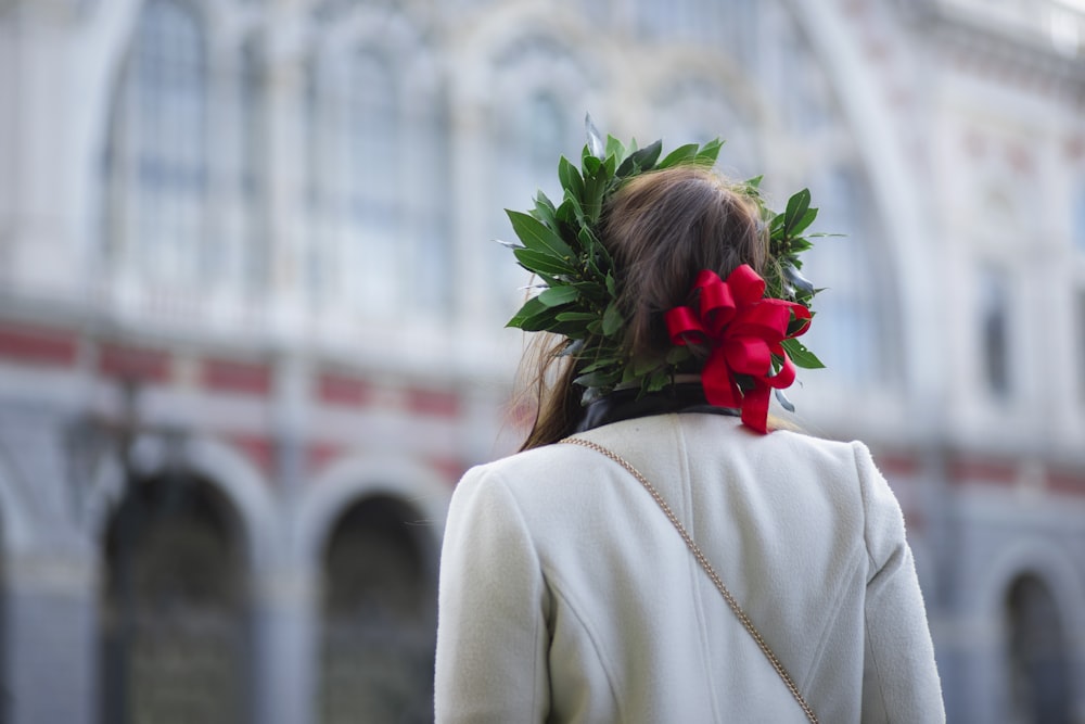 woman facing to a building wearing a floral headpiece