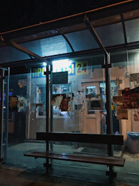 A busy bus stop shelter wrapped with creative outdoor ads in a bustling city area.