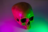 Close-up of a vibrant neon skull tattoo glowing under studio lights.