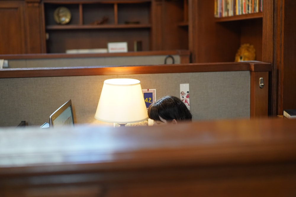 person using computer beside lamp