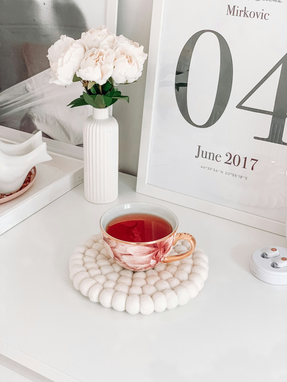 red and white ceramic teacup filled with red liquid