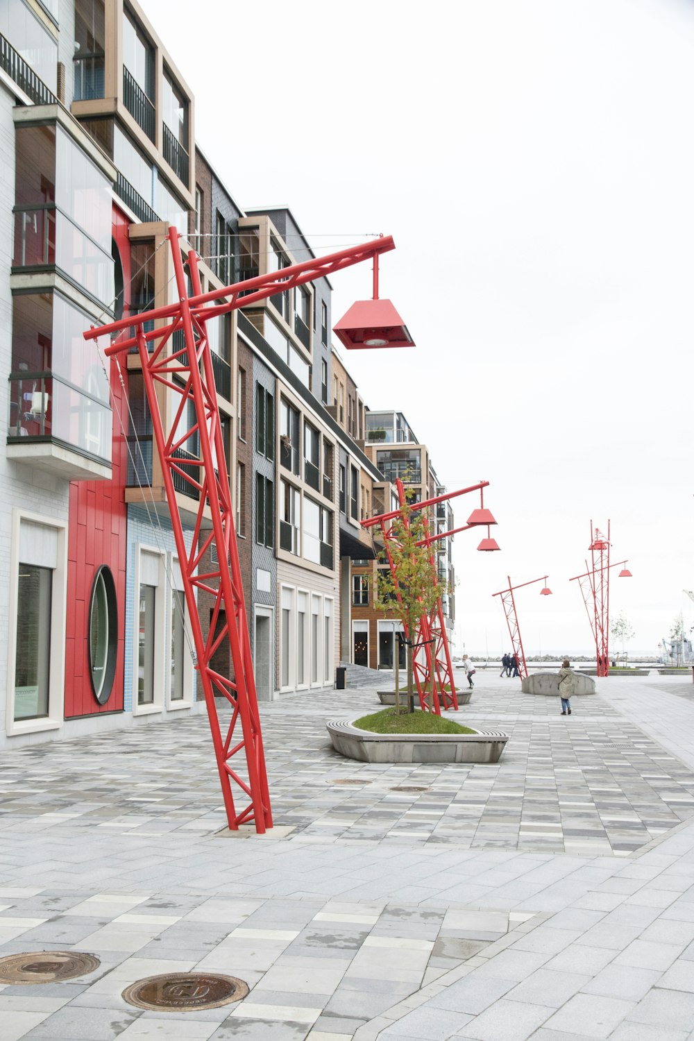 red concrete outdoor lamp post near clear glass walled building